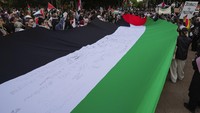 Ini penampakan bendera Palestina raksasa yang dibentangkan selama aksi berlangsung di Sydney, Australia, Sabtu (4/11/2023).
