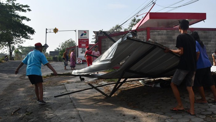 Dampak angin puting beliung di Madiun Warga memindahkan atap teras bangunan toko yang roboh akibat angin puting beliung di Desa Klecorejo, Mejayan, Madiun, Jawa Timur, Sabtu (4/11/2023). Angin puting beliung yang disertai hujan di wilayah tersebut terjadi pada Jumat (3/11) mengakibatkan sejumlah bangunan rumah, sekolah, toko, kandang rusak dan sejumlah tiang listrik roboh. ANTARA FOTO/Siswowidodo/nym.