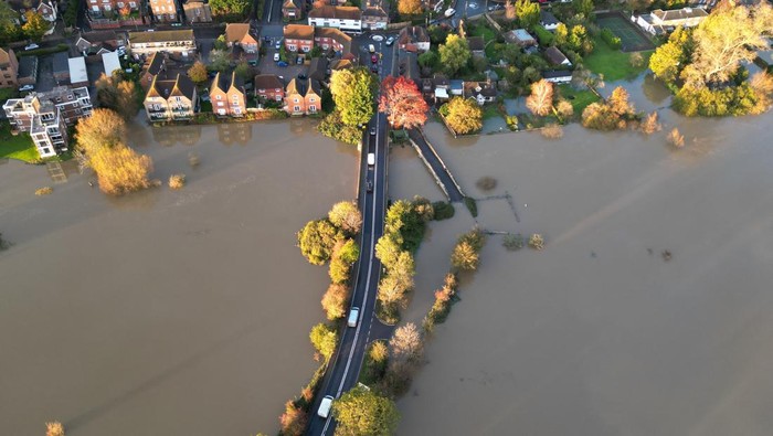 Cars drive along a road surrounded by floodwater after the River Arun burst its banks in the aftermath of Storm Ciaran, in Pulborough, southern Britain, November 3, 2023. REUTERS/Toby Melville