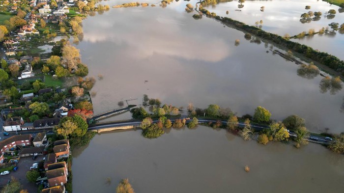 Cars drive along a road surrounded by floodwater after the River Arun burst its banks in the aftermath of Storm Ciaran, in Pulborough, southern Britain, November 3, 2023. REUTERS/Toby Melville