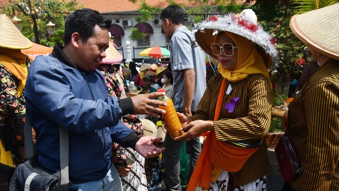 Peserta kirab jamu gendong memberikan jamu kepada pengunjung dalam Festival Jamu Gendong Nusantara di Kota Madiun, Jawa Timur, Sabtu (4/11/2023). Festival tersebut diikuti 1.300 warga perwakilan dari kelurahan dan pelaku usaha jamu gendong guna menyosialisasikan dan membudayakan kembali minum jamu tradisional resep racikan warisan leluhur. ANTARA FOTO/Siswowidodo/nym.