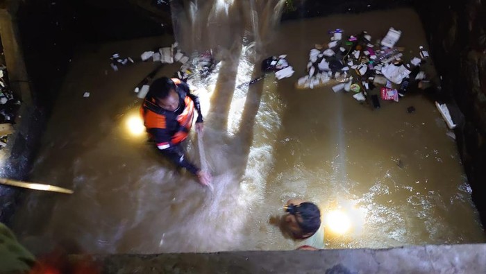 Tim SAR dan relawan melakukan pencarian dengan menyusuri parit lokasi korban hanyut, Sabtu (4/11/2023) malam.