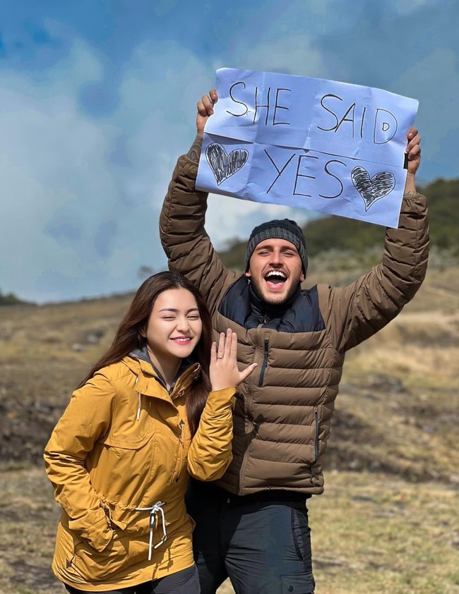 Keduanya pun berpose bersama. Nathalie tampak menunjukkan senyumnya sambil memamerkan cincin lamaran yang melingkar di jari manisnya. Sementara Ladislao yang memegang tulisan ‘She Said Yes’ juga tampak memamerkan ekspresi wajahnya yang tak kalah bahagia. Foto: Instagram/@nathalieholscher