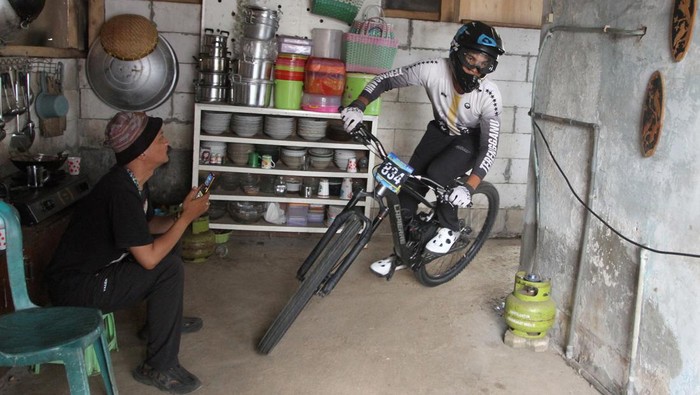 Pebalap sepeda Anantha Djawa berusaha melewati lintasan berupa pekarangan belakang rumah warga dalam kelas Men Open saat kejuaraan Urban Downhil Java Series 2023 di desa wisata Kungkuk, Batu,Jawa Timur, Minggu (5/11/2023). Kejuaraan dengan lintasan di kawasan pemukiman padat penduduk tersebut diikuti ratusan peserta dari berbagai daerah dan mempertandingan delapan kelas antara lain men elite, woman elite, master serta junior. ANTARA FOTO/Ari Bowo Sucipto/YU