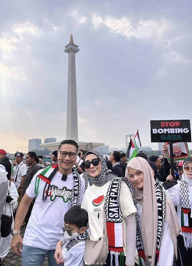 Aksi Bela Palestina berlangsung di area Museum Nasional atau Monas pada Minggu (5/11/2023). Di antara kerumunan massa, sejumlah selebriti juga turun ke jalan untuk menyuarakan aspirasinya. Keluarga Ari Untung termasuk salah satunya. Tampak sang istri, Fenita Ari, memakai kaus semangka (simbol dukungan untuk Palestina) dan scarf keffiyeh sebagai hijab.  (Foto: Instagram)