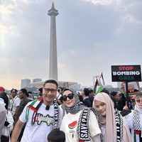 Aksi Bela Palestina berlangsung di area Museum Nasional atau Monas pada Minggu (5/11/2023). Di antara kerumunan massa, sejumlah selebriti juga turun ke jalan untuk menyuarakan aspirasinya. Keluarga Ari Untung termasuk salah satunya. Tampak sang istri, Fenita Ari, memakai kaus semangka (simbol dukungan untuk Palestina) dan scarf keffiyeh sebagai hijab.  (Foto: Instagram)