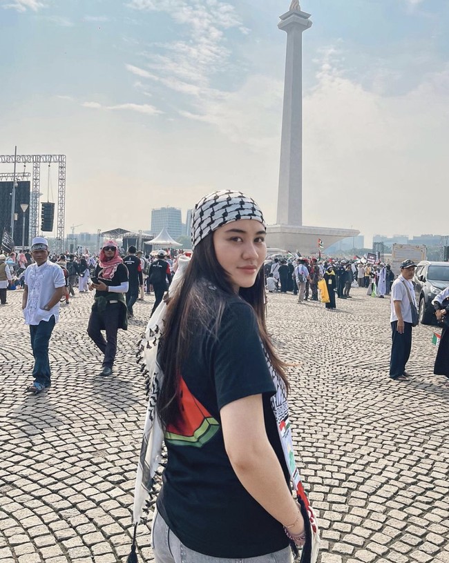 Aaliyah Massaid memadukan scarf dengan kaus hitam bergambar semangka dan jeans abu-abu. (Foto: Instagram)