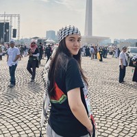 Aaliyah Massaid memadukan scarf dengan kaus hitam bergambar semangka dan jeans abu-abu. (Foto: Instagram)