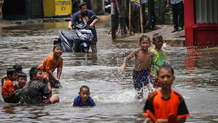 Sejumlah anak bermain air saat banjir di Taman Duta, Depok, Jawa Barat, Minggu (5/11/2023). Hujan deras serta meluapnya air Kali Baru tersebut menyebabkan akses jalan Komplek Taman Duta tergenang air setinggi 30-60 cm. ANTARA FOTO/Asprilla Dwi Adha/YU