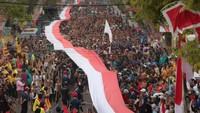 Peserta membentangkan Bendera Merah Putih sepanjang 178 meter saat mengikuti Gerak Jalan Perjuangan (GJP) Mojokerto-Surabaya (Mojosuro) di Mojokerto, Jawa Timur, Sabtu (4/11/2023).