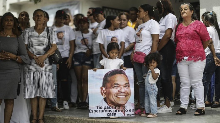 A girl holds a sign that reads in Spanish Uncle Godfather, we wait for you at home promptly, and with the image of Luis Manuel Diaz, father of Colombian soccer star Luiz Diaz, as the family and close friends march to demand his release, in Barrancas, Colombia, Sunday, Nov. 5, 2023. Both of Diaz’s parents were kidnapped in Barrancas last weekend, though his mother was rescued within hours by police. Colombia’s government said that the guerrilla group National Liberation Army, known as ELN, was responsible for the kidnapping. (AP Photo/Ivan Valencia)