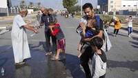 Sesekali mereka berhenti untuk menerima air minum pemberian warga di jalan yang dilalui menuju pengungsian.  