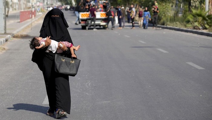 Gendong Balita, Warga Gaza Ngungsi dengan Berjalan Kaki Serangan Israel yang masih berlanjut membuat warga Gaza mengungsi. Sebagian dari mereka mengungsi dengan menggendong anaknya yang masih balita.