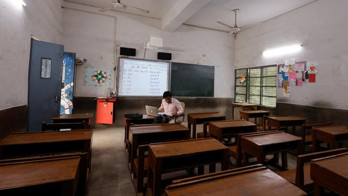 India Kembali Berlakukan Sekolah Online Gegara Polusi Udara A teacher conducts online classes in an empty classroom after primary schools were ordered shut by the Delhi government for Friday and Saturday as the air quality index (AQI) plummeted, on a smoggy morning in New Delhi, India, November 3, 2023. REUTERS/AnushreeΒ Fadnavis
