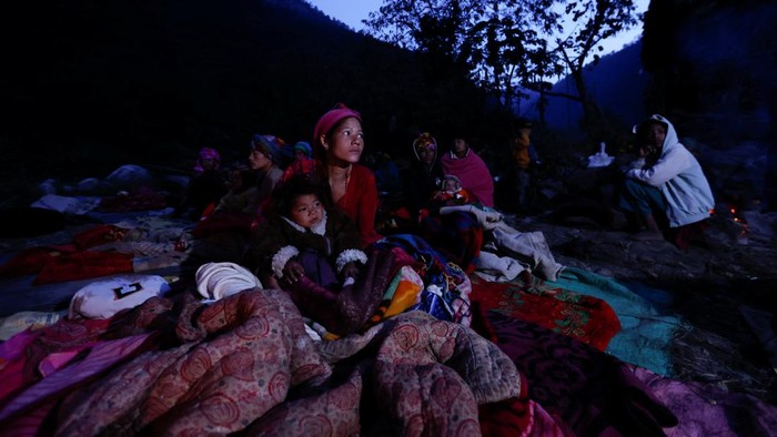Korban Gempa Nepal Tidur di Luar Ruangan Saat Cuaca Dingin A family sits next to the fire to keep themselves warm early in the morning after spending the night out in the open after an earthquake in Rukum, Nepal November 5, 2023. REUTERS/Navesh Chitrakar