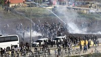 Polisi Turki menembakkan gas air mata untuk membubarkan unjuk rasa pro-Palestina yang dilakukan di luar Pangkalan Udara Incirlik, Turki tenggara. Pangkalan militer itu menampung pasukan Amerika Serikat (AS) di Turki. (AP Photo/Mehmet Sancakzade) 