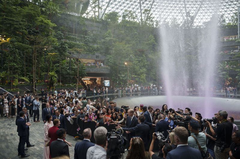 Britain's Prince William, left, is greeted by public as he arrives at Jewel Changi airport, Singapore, Sunday, Nov. 5, 2023. (AP Photo/Vincent Thian)