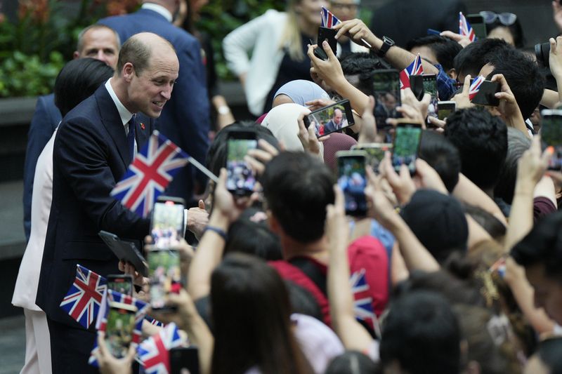 Britain's Prince William, left, is greeted by public as he arrives at Jewel Changi airport, Singapore, Sunday, Nov. 5, 2023. (AP Photo/Vincent Thian)
