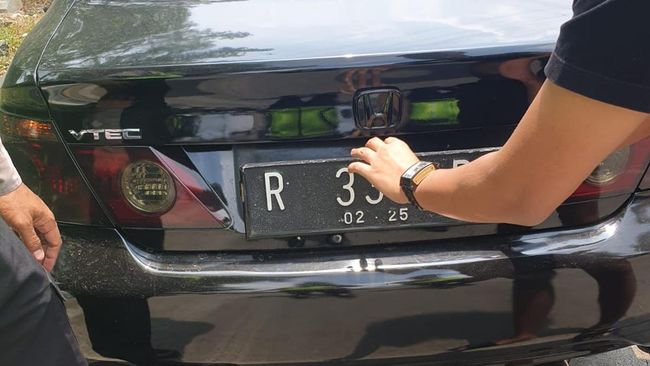 Polisi menilang pengemudi sedan berpelat palsu R-33-PI di Jalan Margonda Depok.