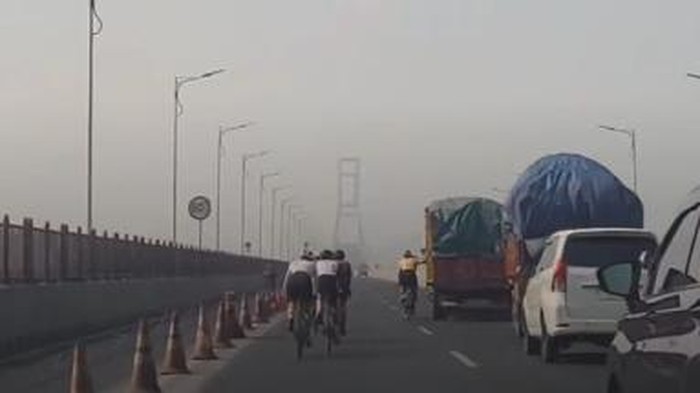 Sejumlah pesepeda masuk ke jalur cepat Jembatan Suramadu. Beberapa di antara mereka bahkan berpegangan atau gandol truk.
