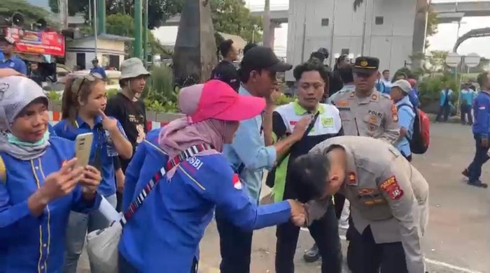 Kapolsek Setiabudi Kompol Arif Purnama Oktora menyalami ibu-ibu peserta demo di depan Kemnaker, Selasa (7/11/2023) sore.