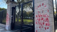 Selain cetakan tangan, massa juga mencoret gerbang itu dengan tulisan Free Palestine.