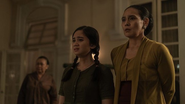 Ine Febriyanti sebagai ibu Dian Sastrowardoyo juga memakai kebaya kutubaru berwarna hijau, yang dipadukan dengan stagen berwarna merah. Seperti yang terlihat dalam salah satu adegan emosional dalam serial Netflix tersebut. Foto: Instagram