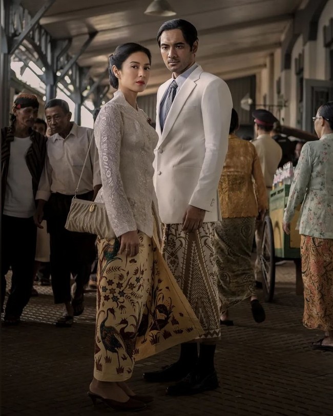 Tak melulu warna hitam. Dian Sastrowardoyo juga memakai kebaya brokat putih, seperti yang terlihat dalam poster dan episode akhir Gadis Kretek. Kebaya itu memiliki aksen kerah yang tinggi di belakang lehernya dan dipadukan dengan jarit batik berwarna coklat kekuningan. Foto: Instagram