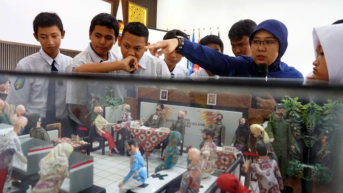 Komisioner KPU Kota Blitar Ninik Sholikah (Kanan) menjelaskan denah Tempat Pemungutan Suara (TPS) kepada sejumlah siswa SMP saat Pengenalan Pemilu sejak dini di Aula KPU Kota Blitar, Jawa Timur, Selasa (7/11/2023). Meski belum memenuhi syarat sebagai pemilih, pengenalan pemilu kepada pelajar SMP tersebut bertujuan untuk mensosialisasikan tentang sistem dan nilai-nilai demokrasi melalui pemilu yang bisa diterapkan di lingkungan sekolah dimulai dari pemilihan ketua kelas, hingga ketua OSIS. ANTARA FOTO/Irfan Anshori/aww.