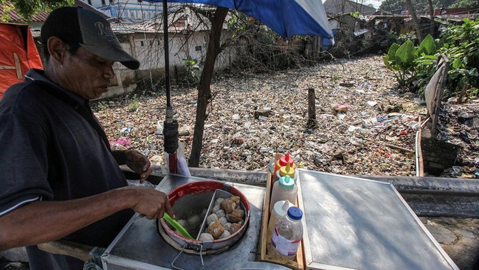 Sungai di Ciawi Dipenuhi Sampah Pedagang berjualan dengan latar belakang tumpukan sampah di kali kawasan Simpang Ciawi, Kabupaten Bogor, Jawa Barat, Selasa (7/11/2023). Kondisi itu karena tidak adanya kesadaran masyarakat untuk membuang sampah pada tempatnya. ANTARA FOTO/Yulius Satria Wijaya/aww.