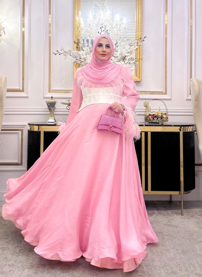 Berbeda dengan Tasya Farasya, Tasyi memilih tampil mengenakan busana berwarna cerah. Ia memilih gaun panjang berwarna merah muda dengan aksen seperti ikat pinggang tebal berwarna putih di bagian perutnya. Penampilannya itu juga dilengkapi dengan hijab dan tas berwarna senada. Foto: Instagram/@tasyiiathasyia