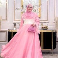 Berbeda dengan Tasya Farasya, Tasyi memilih tampil mengenakan busana berwarna cerah. Ia memilih gaun panjang berwarna merah muda dengan aksen seperti ikat pinggang tebal berwarna putih di bagian perutnya. Penampilannya itu juga dilengkapi dengan hijab dan tas berwarna senada. Foto: Instagram/@tasyiiathasyia