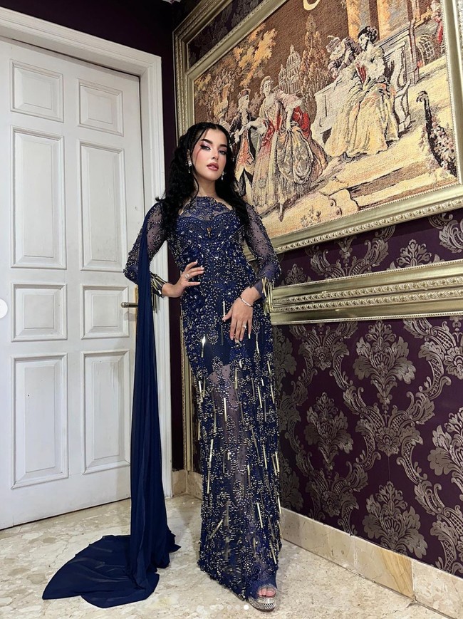 Mengusung tema fairy, Tasya Farasya hadir dengan pakaian bertema dark fairy. Ia memilih dress panjang berwarna biru tua yang dipenuhi dengan payet. Di salah satu bagian pundaknya terdapat kain panjang polos yang menjuntai. Foto: Instagram/@tasyafarasya