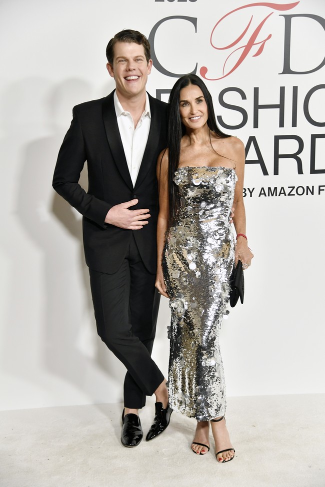 Turut melengkapi gaya Demi, sepasang sandal heels minimalis hitam yang dipadu clutch senada. Riasan dengan pulasan warna nude pada bibir serta rambut panjang yang dibiarkan tergerai bebas sukses menonjolkan kecantikan alaminya. (Foto: Evan Agostini/Invision/AP)