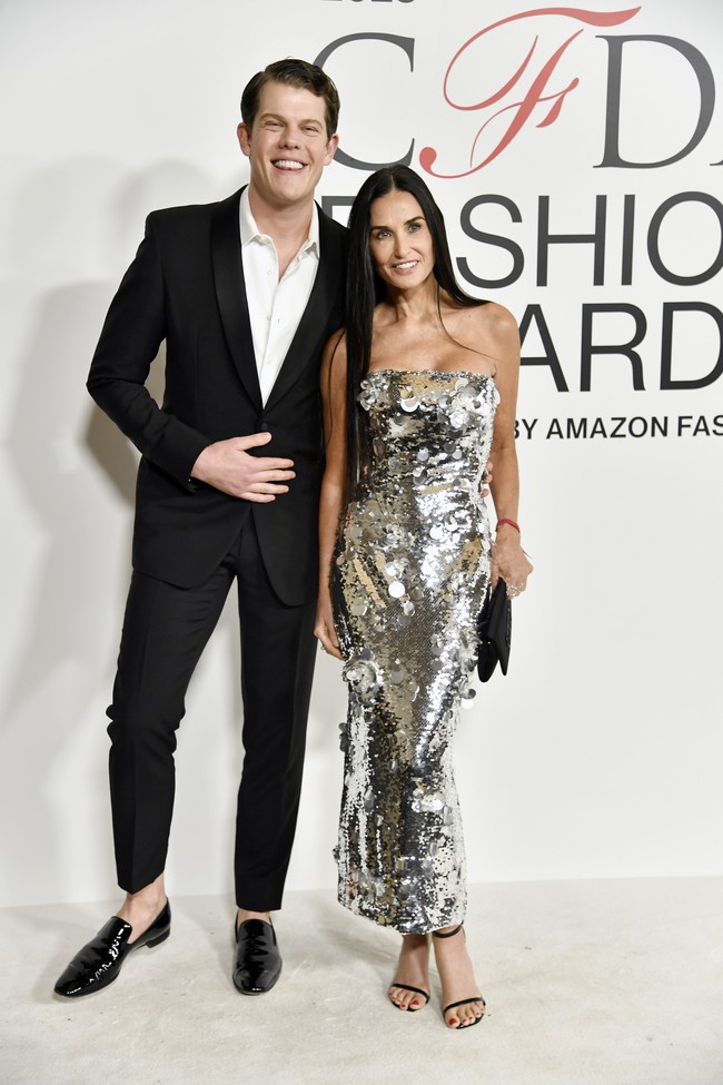 Dirancang oleh Wes Gordon, gaun Demi penuh dengan payet silver berkilauan yang memantulkan cahaya sehingga sukses mengalihkan perhatian padanya. Sang desainer ikut mendampingi Demi di karpet merah. (Foto: Evan Agostini/Invision/AP)