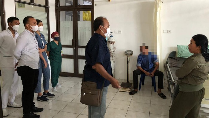 I Nengah AWS (duduk) yang menebas ayah kandungnya saat akan menjalani pemeriksaan kejiwaan di RSUD Karangasem, Selasa (7/11/2023). (Dok. Polsek Karangasem)