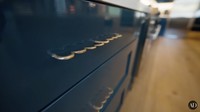 Contohnya pegangan kabinet ini yang bukan lurus biasa, melainkan meliuk-liuk seperti gelombang. Warnanya emas dan kontras dengan warna dasar kabinet. Foto: YouTube Architectural Digest