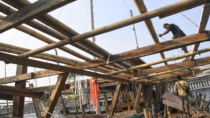 Pekerja menyelesaikan pembuatan kapal bagan apung di Kalibaru, Cilincing, Jakarta Utara, Selasa (7/11/2023). Kapal yang mampu menangkap ikan sekitar lima ton yang dikerjakan sekitar satu bulan itu menelan biaya Rp1,4 miliar hingga Rp1,8 miliar. ANTARA FOTO/M Risyal Hidayat/nym.