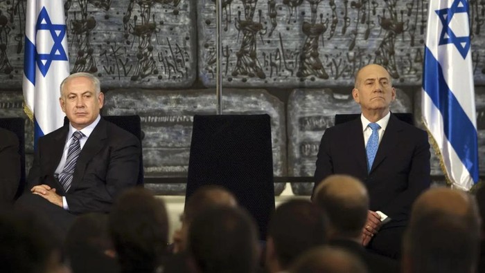PM Israel Benjamin Netanyahu (kiri) duduk berdampingan dengan mantan PM Ehud Olmert dalam foto tahun 2009 PM Israel Benjamin Netanyahu (kiri) duduk berdampingan dengan mantan PM Ehud Olmert dalam foto tahun 2009. (AP Photo/Menahem Kahana, Pool)