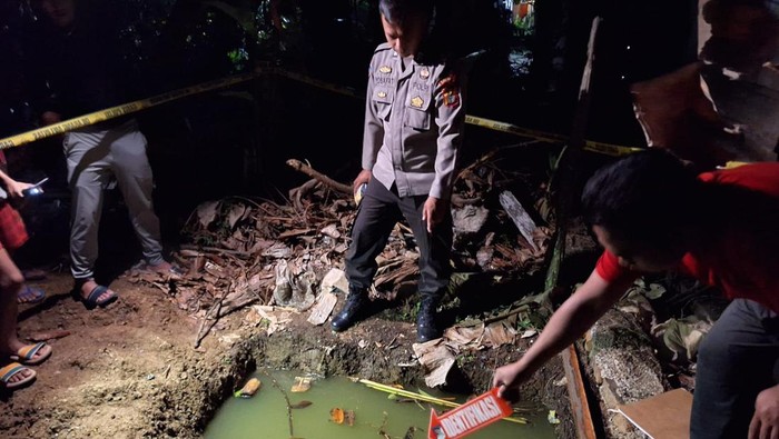 Polisi saat olah TKP di lubang septic tank tempat korban balita ditemukan.