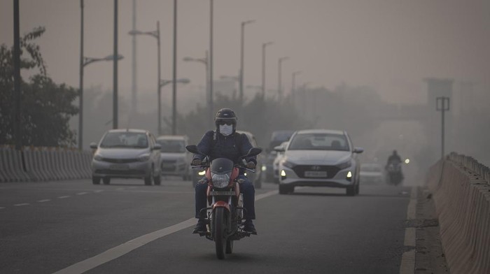 A motorcyclist drives wearing pollution mask amid smog in New Delhi, India, Tuesday, Nov. 7, 2023. Masks are back on the streets as residents of the capital city grapple with the annual surge in air pollution that has engulfed the region. (AP Photo/Altaf Qadri)