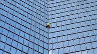 Pendaki gedung pencakar langit Prancis Alain Robert memanjat gedung Tour TotalEnergies Coupole di Puteaux, Paris, Prancis, Senin (6/11/2023).