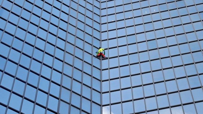 French skyscraper climber Alain Robert climbs the Tour TotalEnergies Coupole skyscraper to call for 
