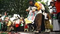 Seorang peserta aksi melakukan aksi tabur bunga.  