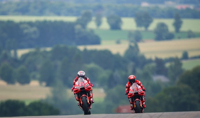 Ducati Lenovo Teams Italian rider Enea Bastianini (L) and Ducati Lenovo Teams Italian rider Francesco Bagnaia steer their motorbikes during the first free practice for the MotoGP German motorcycle Grand Prix at the Sachsenring racing circuit in Hohenstein-Ernstthal near Chemnitz, eastern Germany, on June 16, 2023. (Photo by Ronny Hartmann / AFP)
