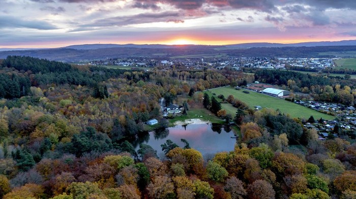 Colourful trees frame a small lake outside of the city of Usingen, Germany, Thursday, Nov. 9, 2023. (AP Photo/Michael Probst)