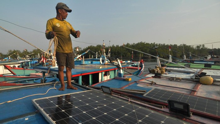 Nelayan menyambungkan kabel listrik dengan panel surya di atas kapal di kawasan pelabuhan Baai, Kota Bengkulu, Rabu (8/11/2023). Nelayan dengan kapal berukuran 6 gross ton (GT) sampai 20 GT di wilayah tersebut mulai bermigrasi dari penggunaan aki ke pembangkit listrik tenaga surya (PLTS) untuk menghemat ongkos saat melaut. ANTARA FOTO/Muhammad Izfaldi/aww.
