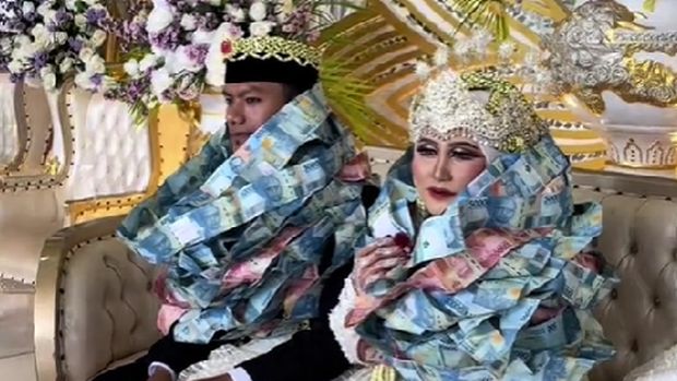 Pasangan pengantin ini dikalungi lembaran uang kertas di Bangkalan, Madura, viral di TikTok.