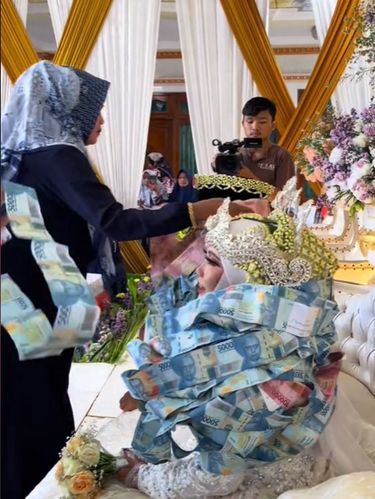 Pasangan pengantin ini dikalungi lembaran uang kertas di Bangkalan, Madura, viral di TikTok.