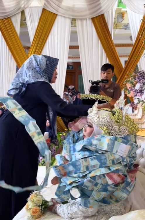 Pasangan pengantin ini dikalungi lembaran uang kertas di Bangkalan, Madura, viral di TikTok.